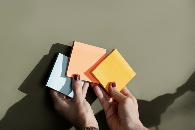 Top view hands holding colorful post its