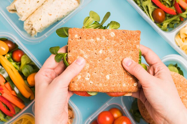 Mani di vista superiore che tengono il panino di cracker