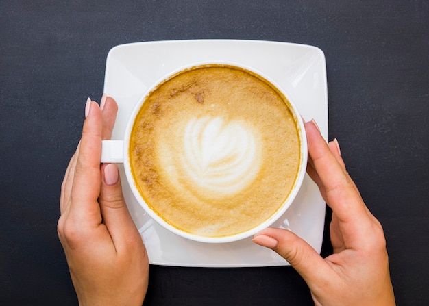 Top view hands holding cup of coffee