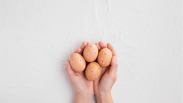 Top view of hands holding decorated easter eggs