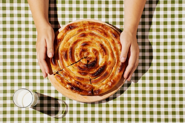 Free photo top view hands holding delicious pie