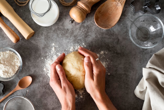 Top view hands holding dough on counter