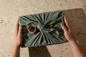 Free photo top view hands holding  furoshiki package