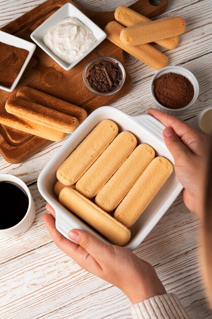 Top view hands holding ladyfingers tray