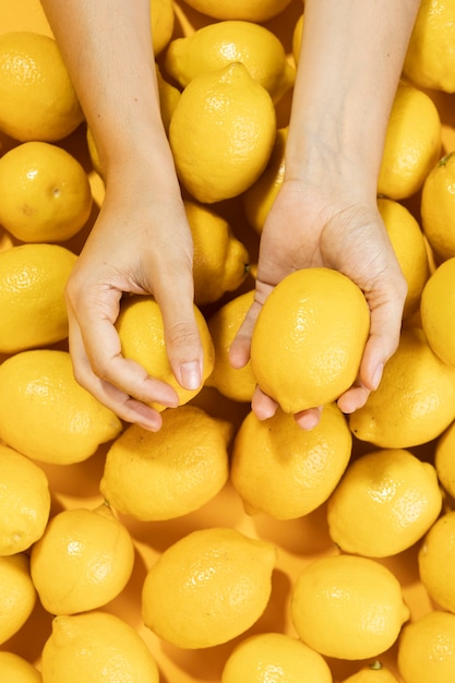 Free photo top view hands holding organic lemon