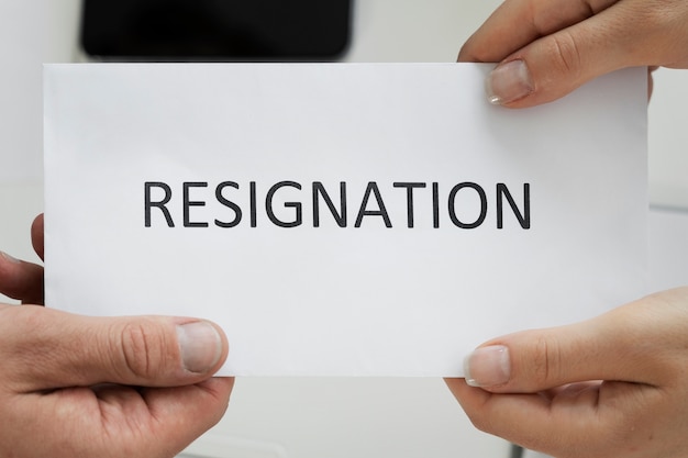 Free photo top view hands holding resignation note