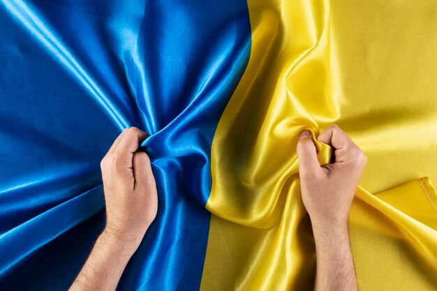 Top view hands holding ukranian flag