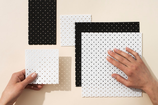 Free photo top view hands and microperforated sheets