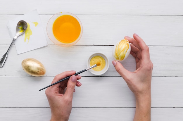 Top view of hands painting egg for easter