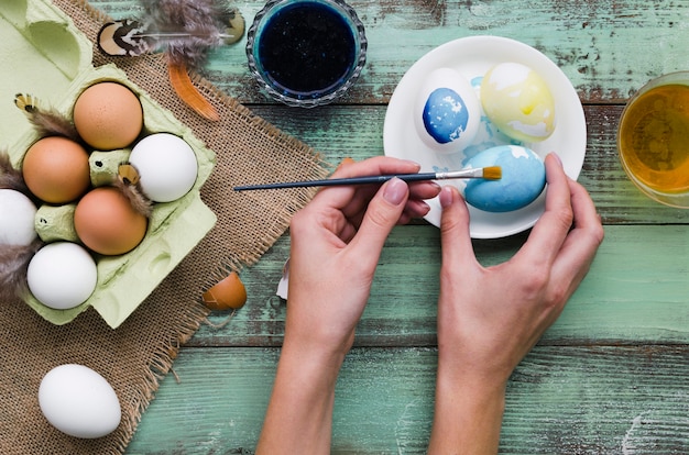 Top view of hands painting eggs for easter