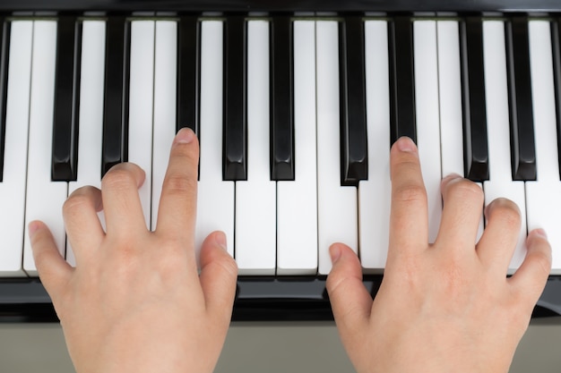 Top view of hands playing piano
