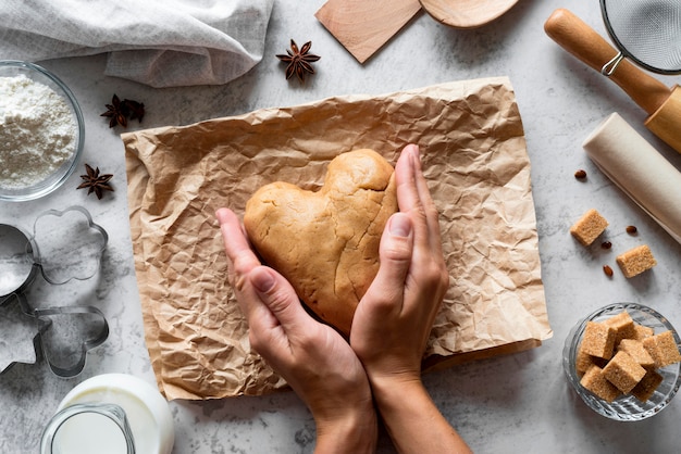 Top view hands shaping dough in heart