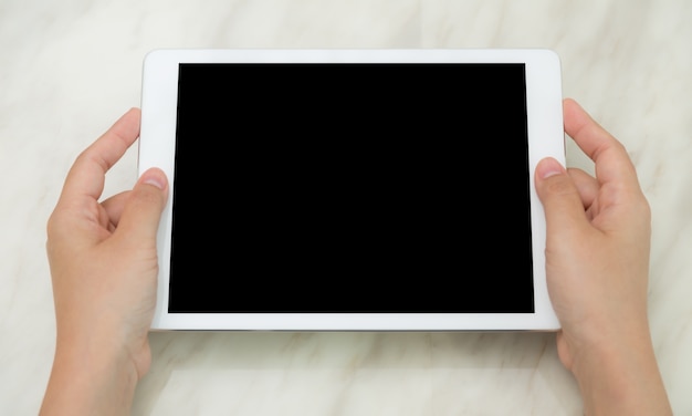 Top view of hands showing a tablet