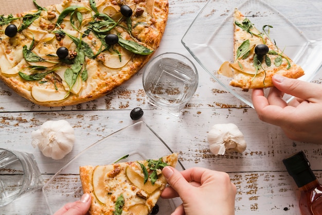 Top view hands taking pizza with garlics