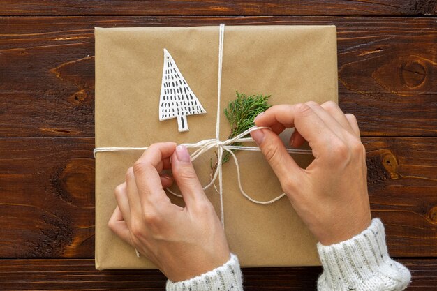 Top view of hands tieing christmas gift