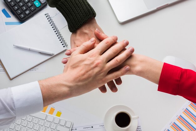 Top view of hands together over desk