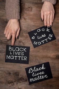 Top view of hands with black lives matter cards