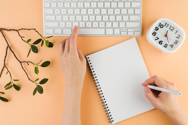 Free photo top view of hands with notebook on desk and keyboard