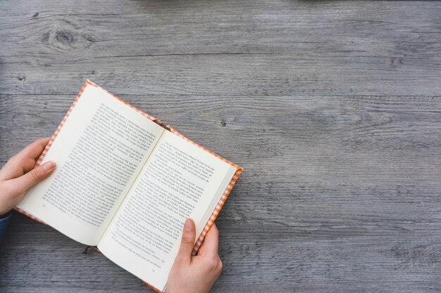 Top view of hands with an open book