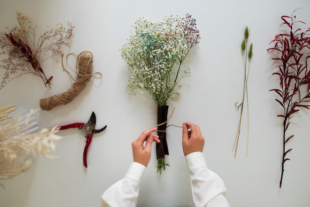 Top view hands working with dried flower