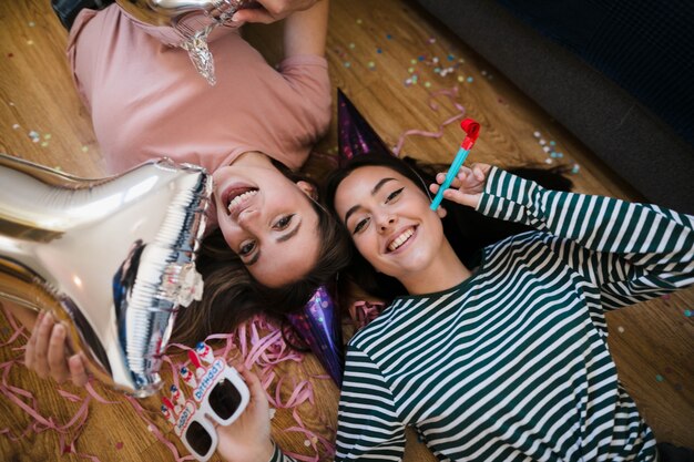 Top view happy girls laying on the floor 