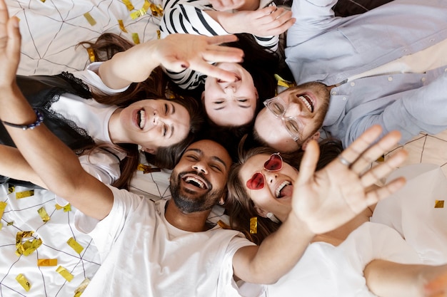 Free photo top view happy people laying together