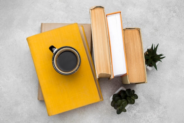 Top view of hardback books on desk with coffee and succulents