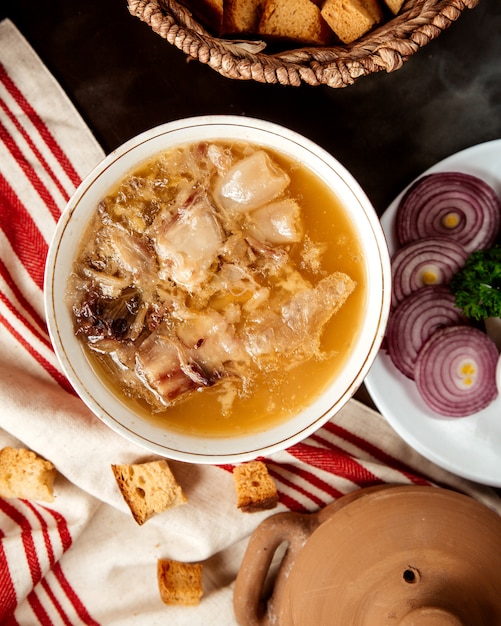 Free photo top view hash traditional azerbaijani dish in a kyasa plate with onions and crackers