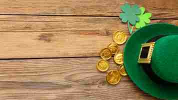 Free photo top view hat and gold coins frame