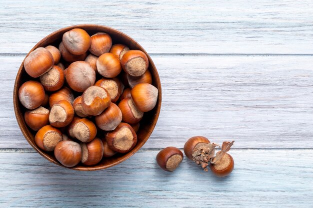 Top view of hazelnuts in a bowl on wooden rustic