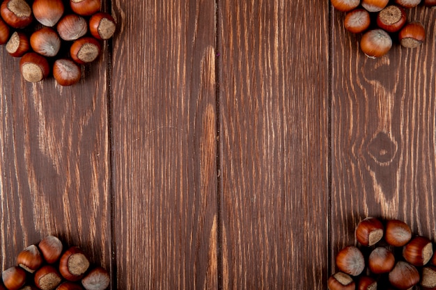 Top view of hazelnuts in shell on wooden background with copy space