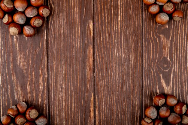 Top view of hazelnuts in shell on wooden background with copy space