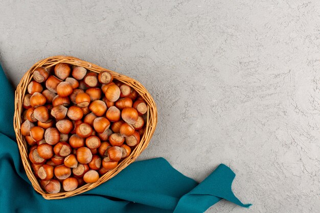 top view hazelnuts whole inside basket on the grey background