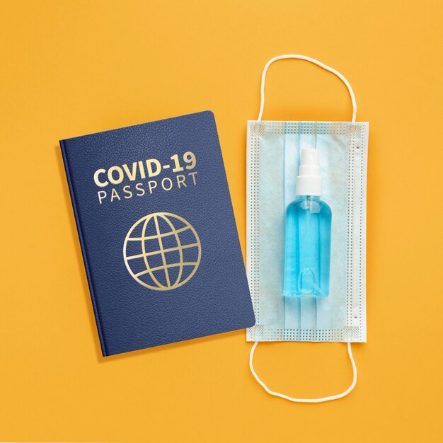 Top view of health passport with medical mask and hand sanitizer