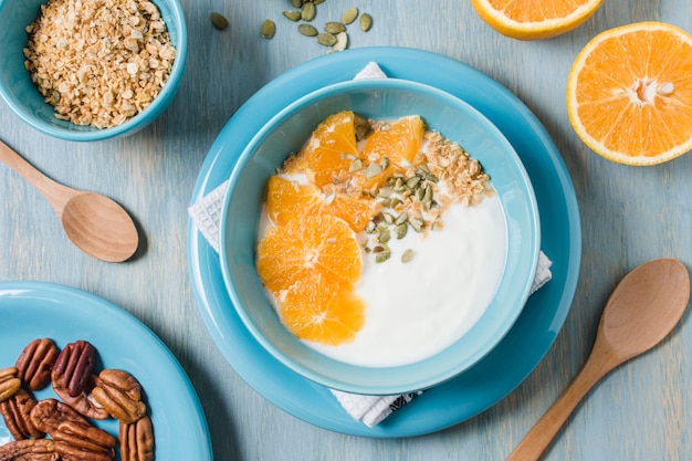 Вид сверху здоровый завтрак с йогуртом и апельсином