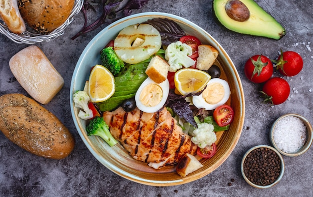 Free photo top view of healthy diet salad with grilled chicken broccoli cauliflower tomato lettuce avocado and lettuce