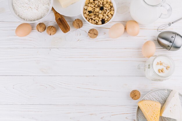 Top view of healthy food ingredients and tools on white wooden table