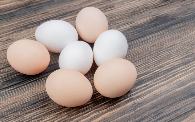 Top view of healthy and fresh chicken eggs isolated on a wooden background