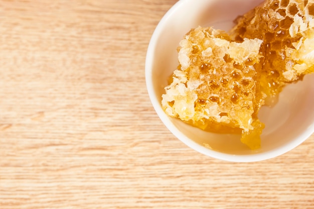 Top view of healthy honeycomb in bowl on wooden table