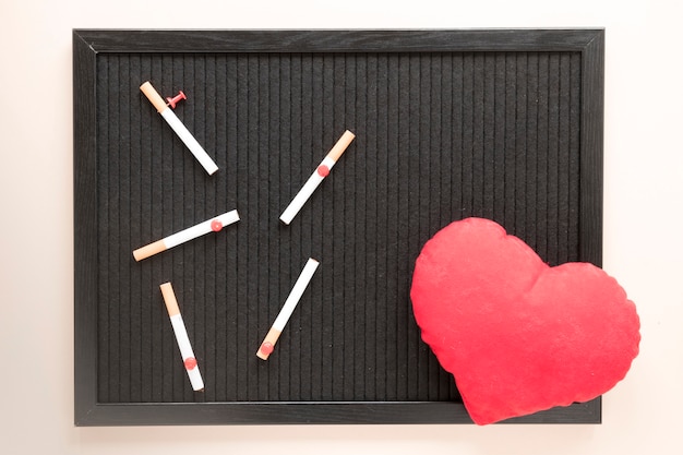 Top view heart and cigarettes on chalkboard