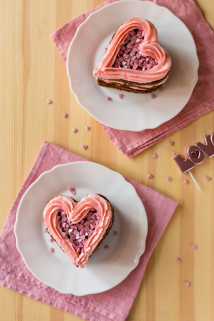 Free photo top view of heart-shaped cake slices on wooden background