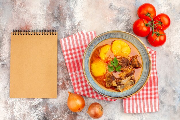 トップビュー自家製bozbashスープキッチンタオル玉ねぎトマトヌード背景のノート