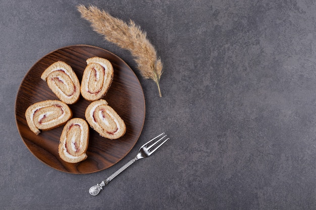 Top view of homemade cake rolls on wooden board