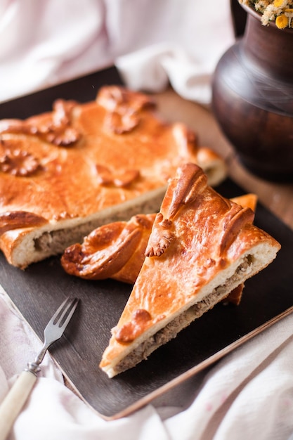 Top view of homemade gata on a black plate on a wooden table