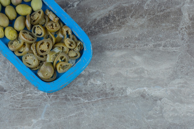 Foto gratuita vista dall'alto della fetta di sottaceto fatta in casa e delle olive verdi sul piatto di legno.