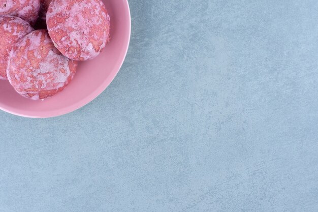 Вид сверху домашнего розового печенья в розовой миске.