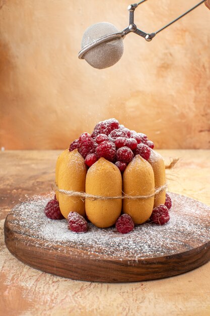 Vista dall'alto della torta morbida fatta in casa con frutta sul tagliere di legno sulla tavola di colori misti