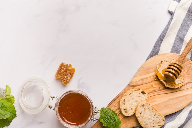 Top view honey jar with food and honeyspoon