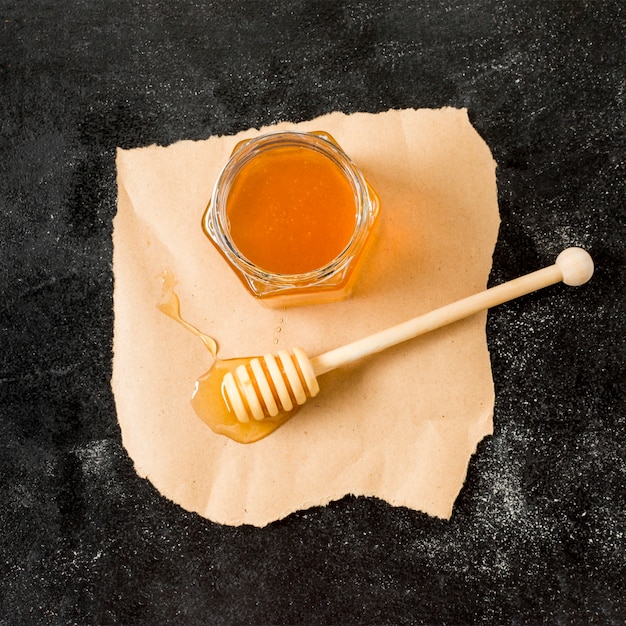 Free photo top view honey jar with spoon