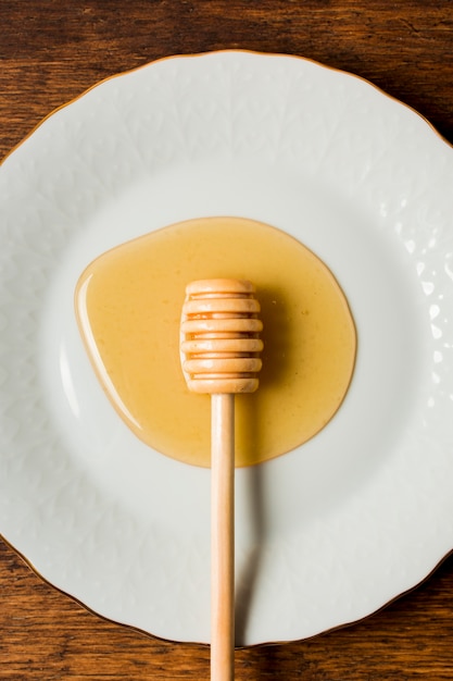 Вид сверху мед на тарелку с ложкой
